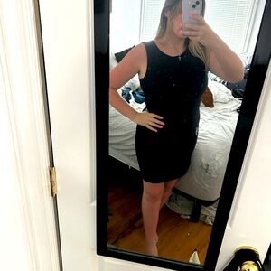 Black detailed black mini dress. Curved round neck line. Zippered back. Size L.